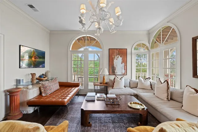 a living room with furniture chandelier and a large window