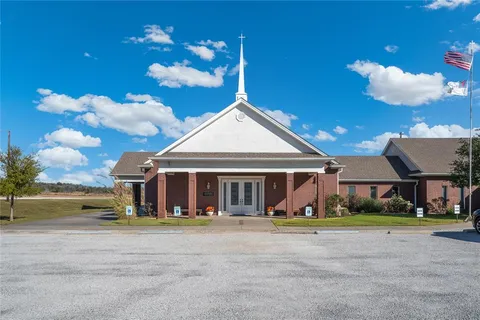 a view of a house with a yard and sitting area