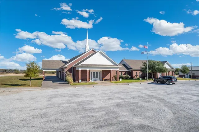 a view of a patio with table and chairs under an umbrella with wooden fence