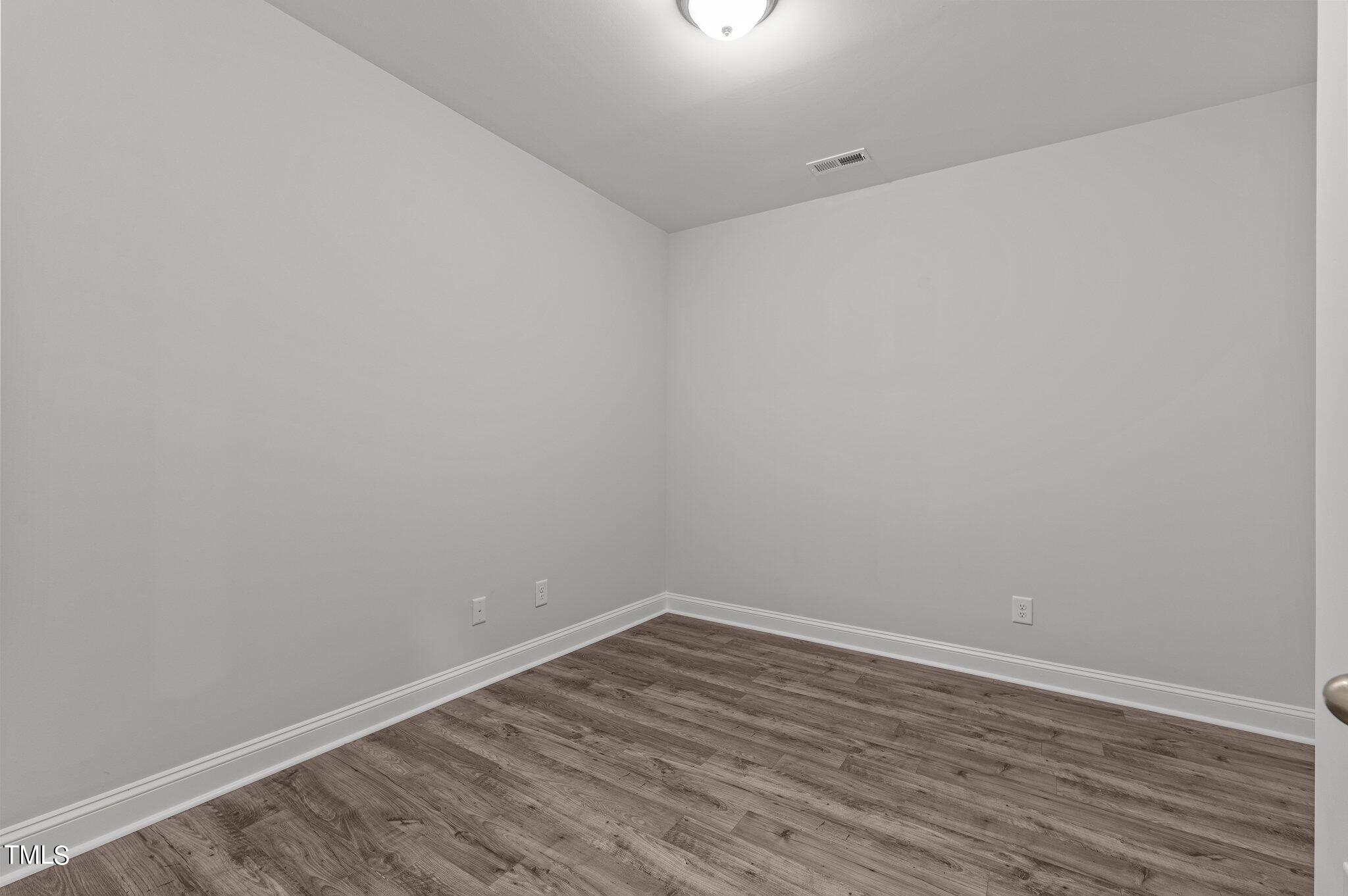 579 Forestville Road Wake Forest, NC 27587 - Photo 18 of 34 a view of an empty room with wooden floor