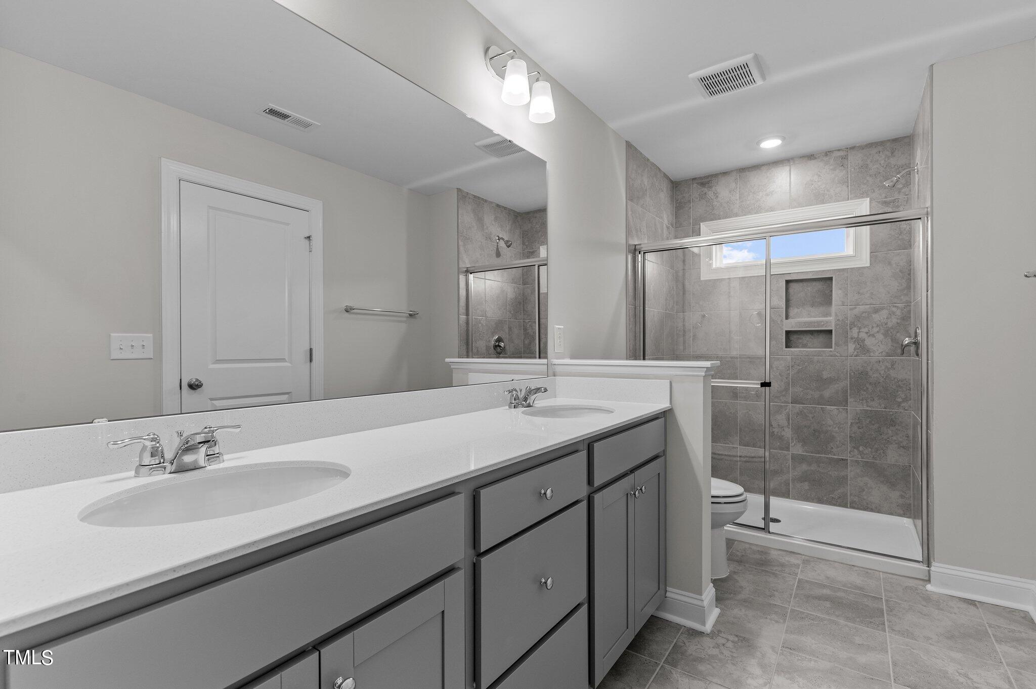 579 Forestville Road Wake Forest, NC 27587 - Photo 21 of 34 a bathroom with a double vanity sink mirror and shower