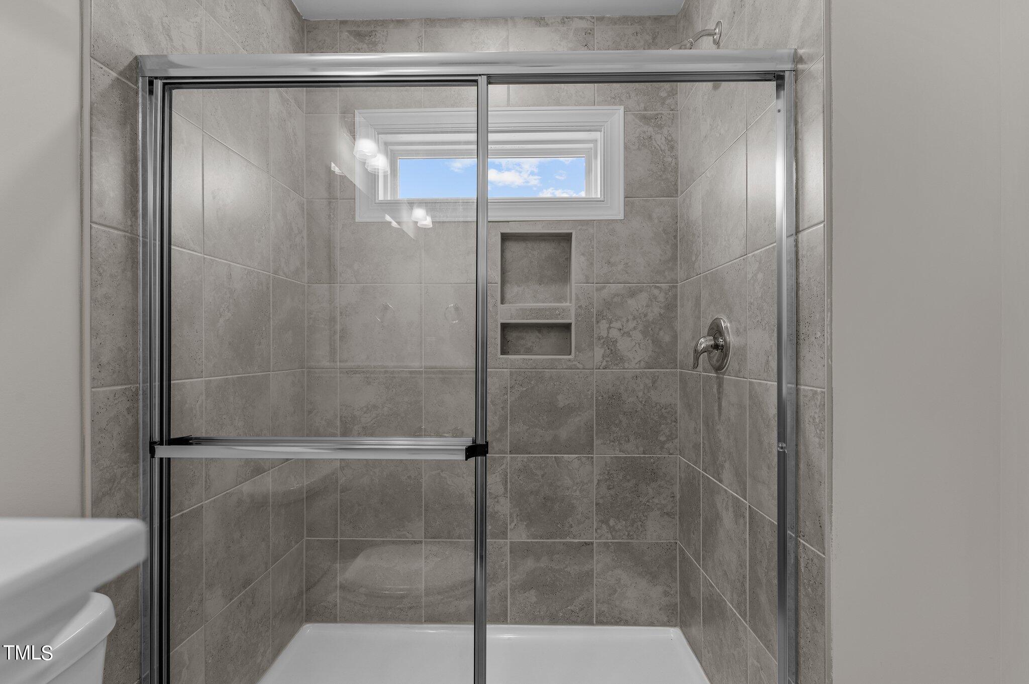 579 Forestville Road Wake Forest, NC 27587 - Photo 22 of 34 a bathroom with a glass shower door