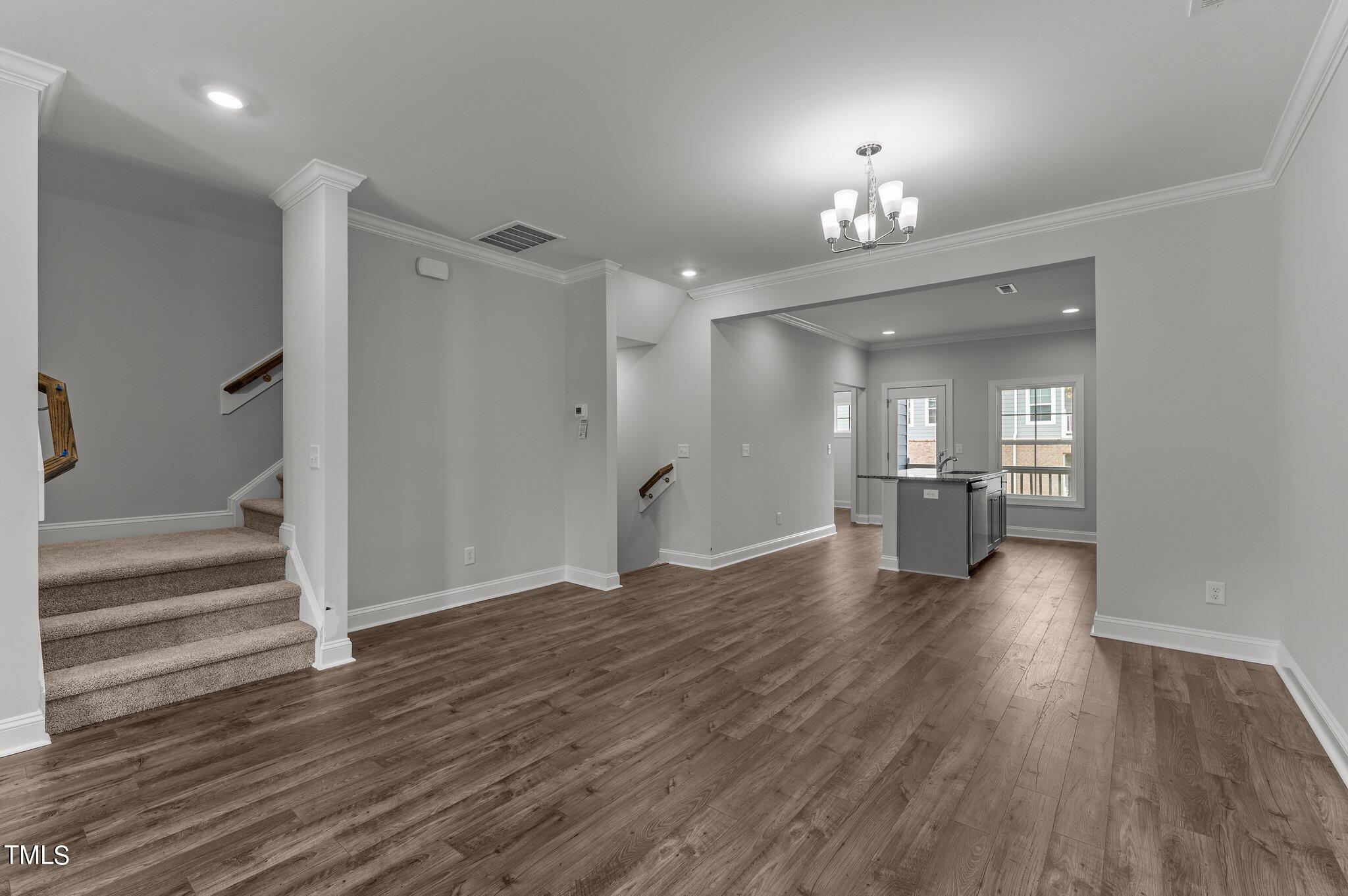 579 Forestville Road Wake Forest, NC 27587 - Photo 5 of 34 a view of a room with a ceiling fan wooden floor and a kitchen