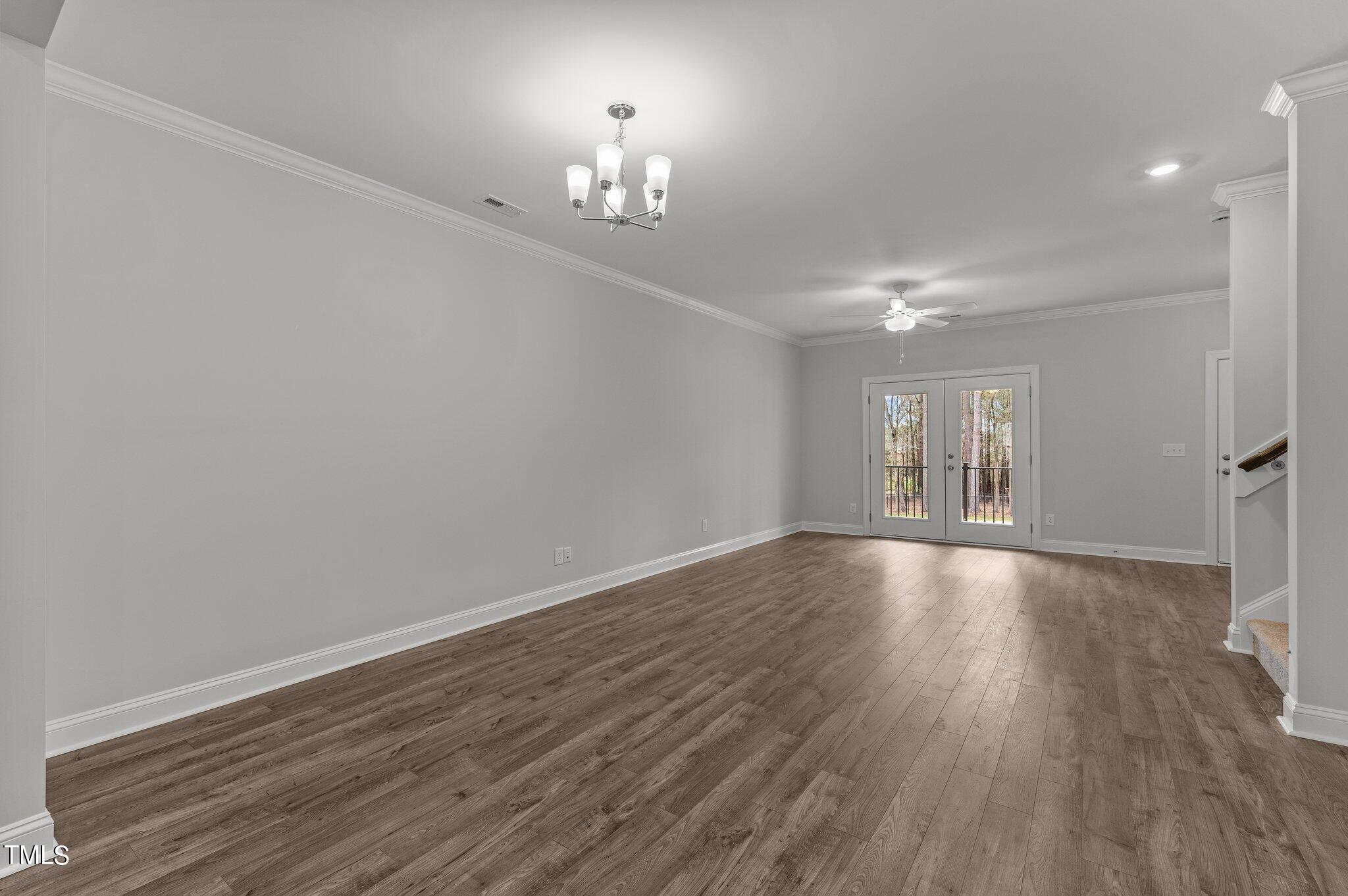 579 Forestville Road Wake Forest, NC 27587 - Photo 6 of 34 a view of an empty room with wooden floor and a chandelier