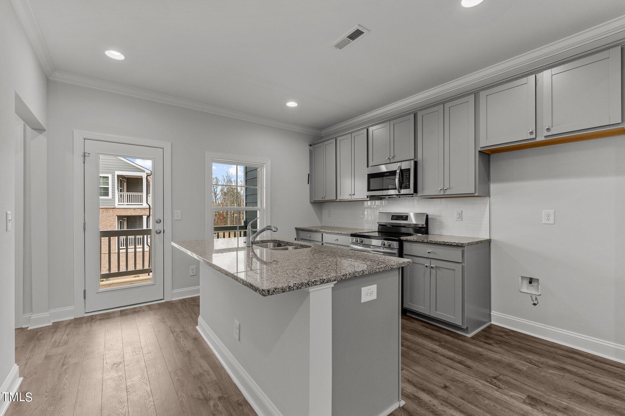 579 Forestville Road Wake Forest, NC 27587 - Photo 7 of 34 a kitchen with stainless steel appliances granite countertop a sink stove and refrigerator