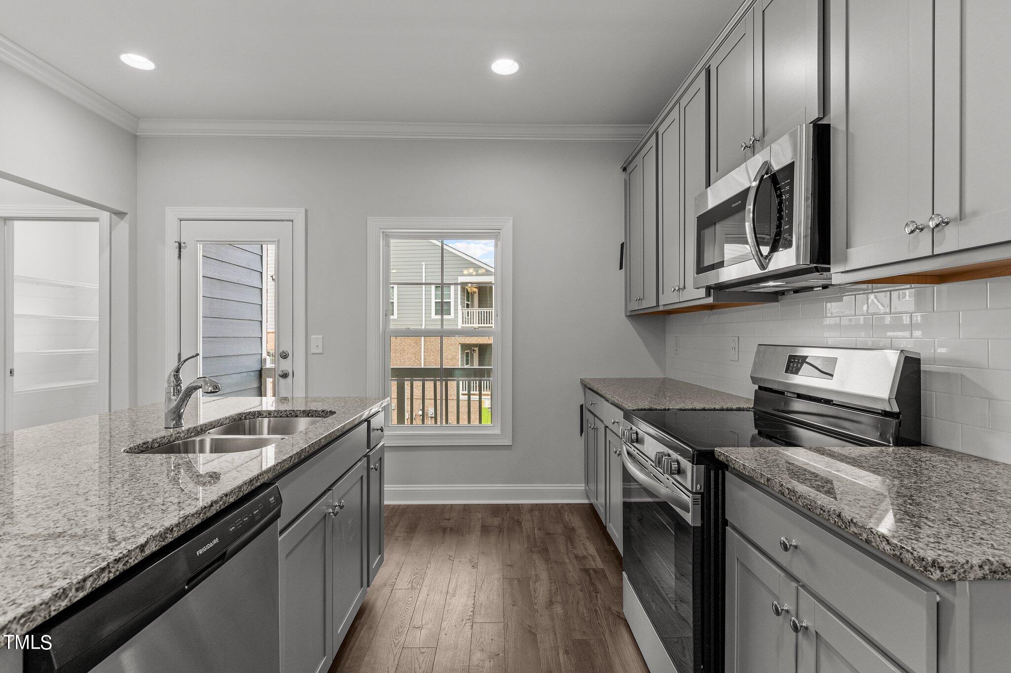 579 Forestville Road Wake Forest, NC 27587 - Photo 8 of 34 a kitchen with granite countertop stainless steel appliances a sink stove top oven and cabinets