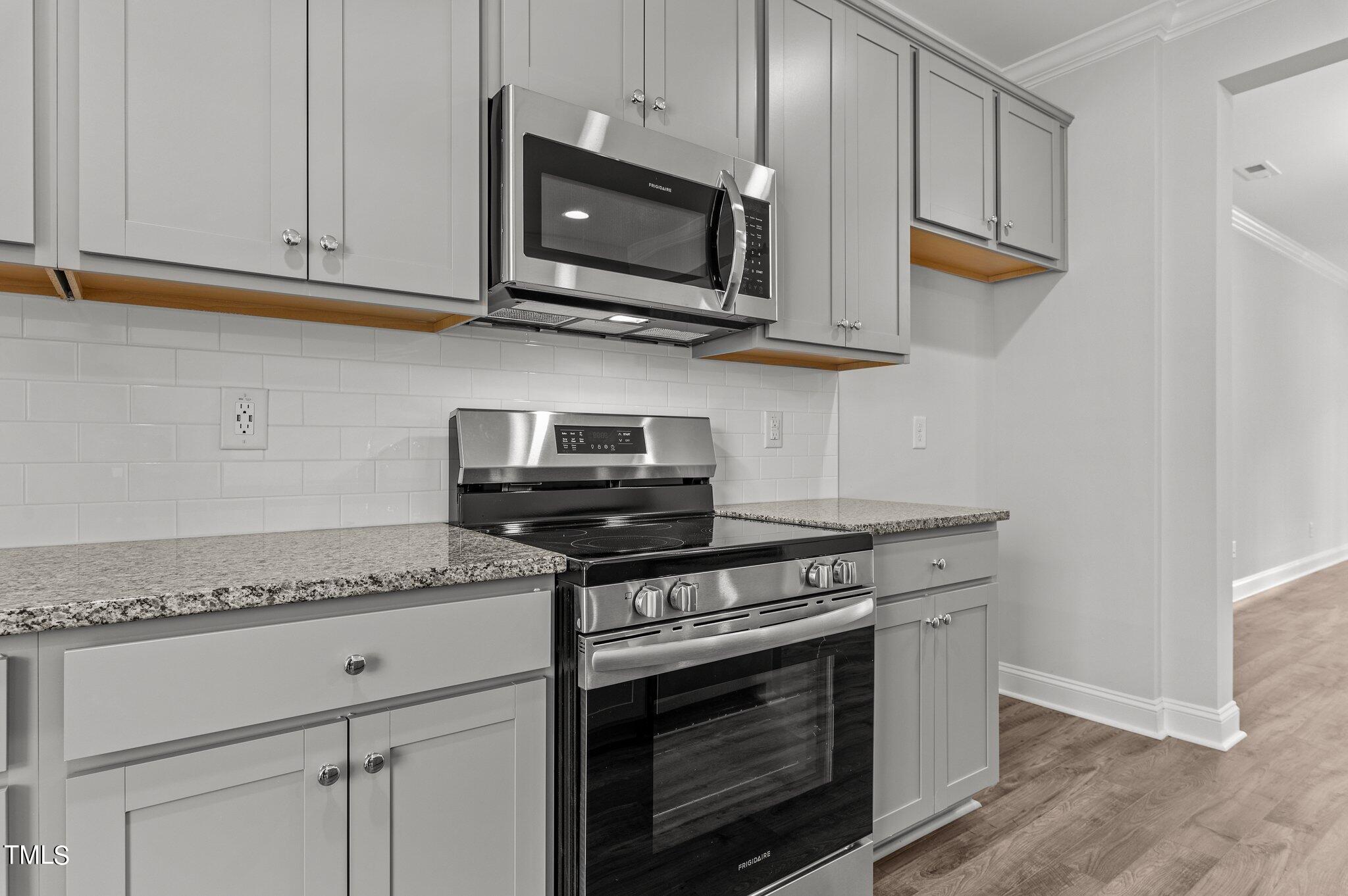 579 Forestville Road Wake Forest, NC 27587 - Photo 10 of 34 a kitchen with stainless steel appliances granite countertop white cabinets and a stove top oven