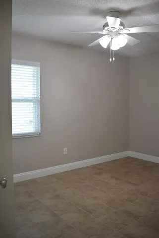 an empty room with a window and a fan