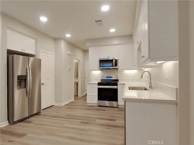 a kitchen with stainless steel appliances granite countertop a refrigerator sink and stove