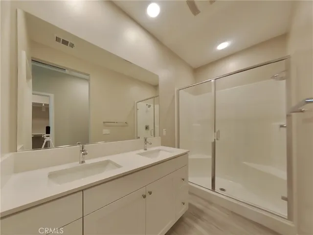 a bathroom with double vanity sink and shower