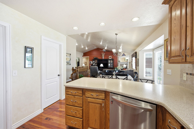 776 Flint Street Layton, UT 84041 - Photo 11 of 41 Kitchen peninsula featuring a light-toned countertop, wood-finish cabinetry, and a stainless steel dishwasher