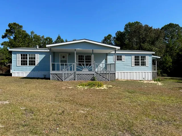 a view of a house with pool and chairs