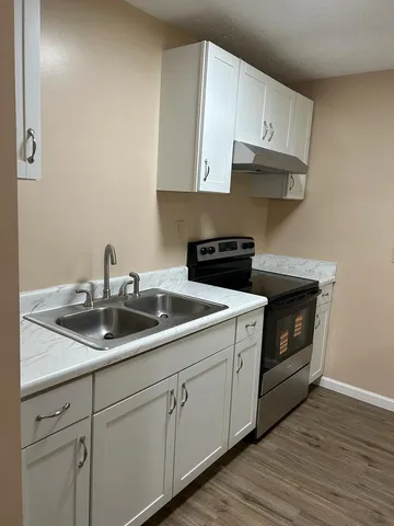 a kitchen with stainless steel appliances granite countertop white cabinets a sink and dishwasher