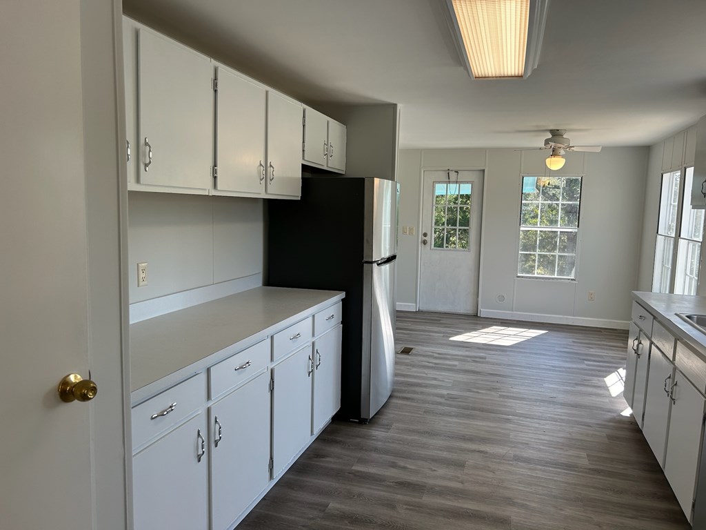 1300 Dr Brooks Road Box Springs, GA 31801 - Photo 7 of 16 a kitchen with white cabinets and wooden floor