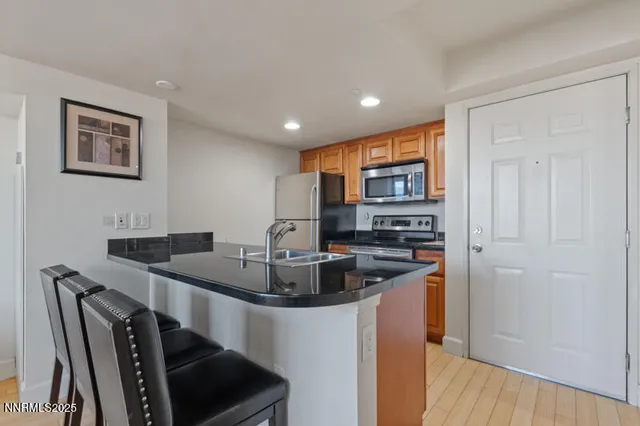 a kitchen with stainless steel appliances granite countertop a sink and a refrigerator