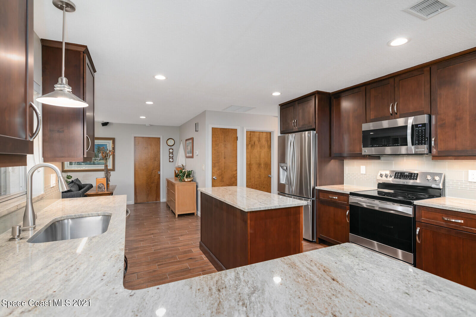 791 Montclair Road Northeast Palm Bay, FL 32905 - Photo 26 of 69 a kitchen with stainless steel appliances kitchen island granite countertop a sink counter space cabinets and stainless steel appliances
