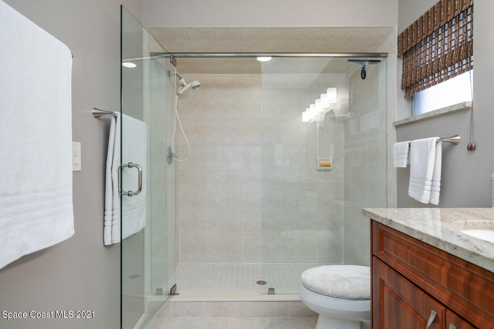 791 Montclair Road Northeast Palm Bay, FL 32905 - Photo 36 of 69 a bathroom with a granite countertop shower sink vanity and toilet