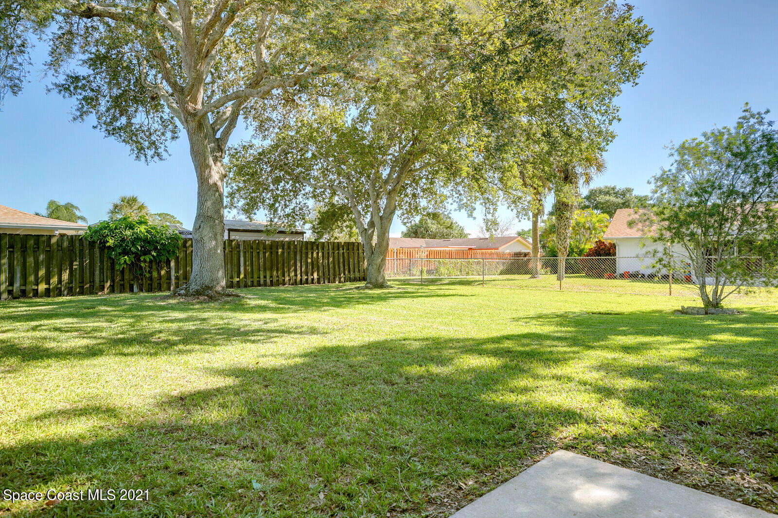 791 Montclair Road Northeast Palm Bay, FL 32905 - Photo 10 of 69 a view of a house with a big yard and large trees