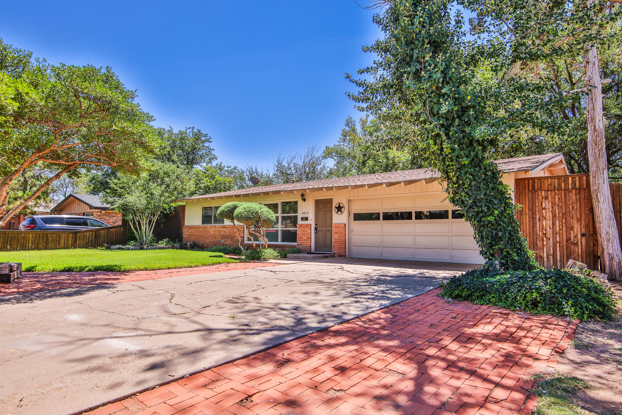 a front view of a house with a yard and trees