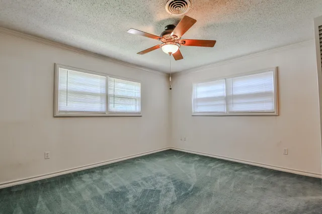 a view of an empty room with a ceiling fan