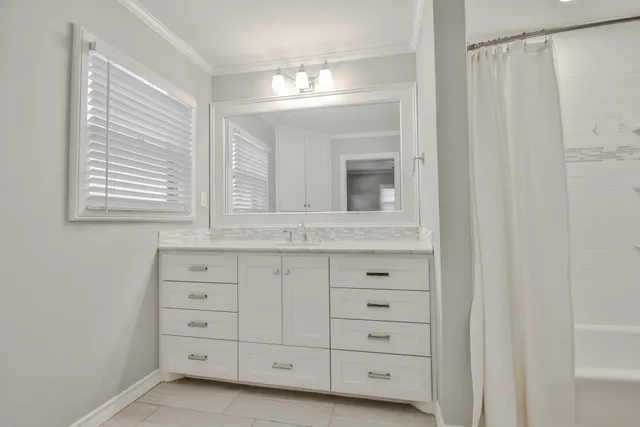 a bathroom with a sink mirror and cabinets