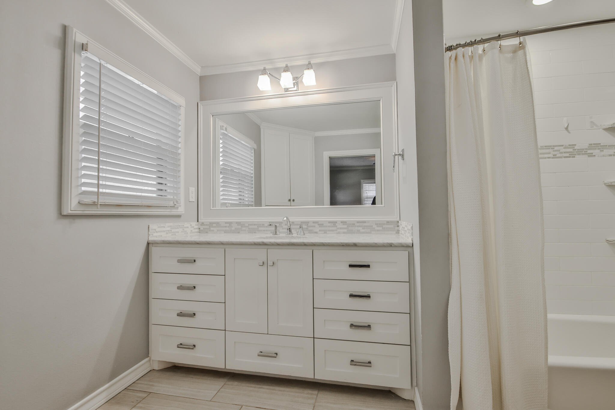 4315 47th Street Lubbock, TX 79413 - Photo 29 of 37 a bathroom with a sink mirror and cabinets