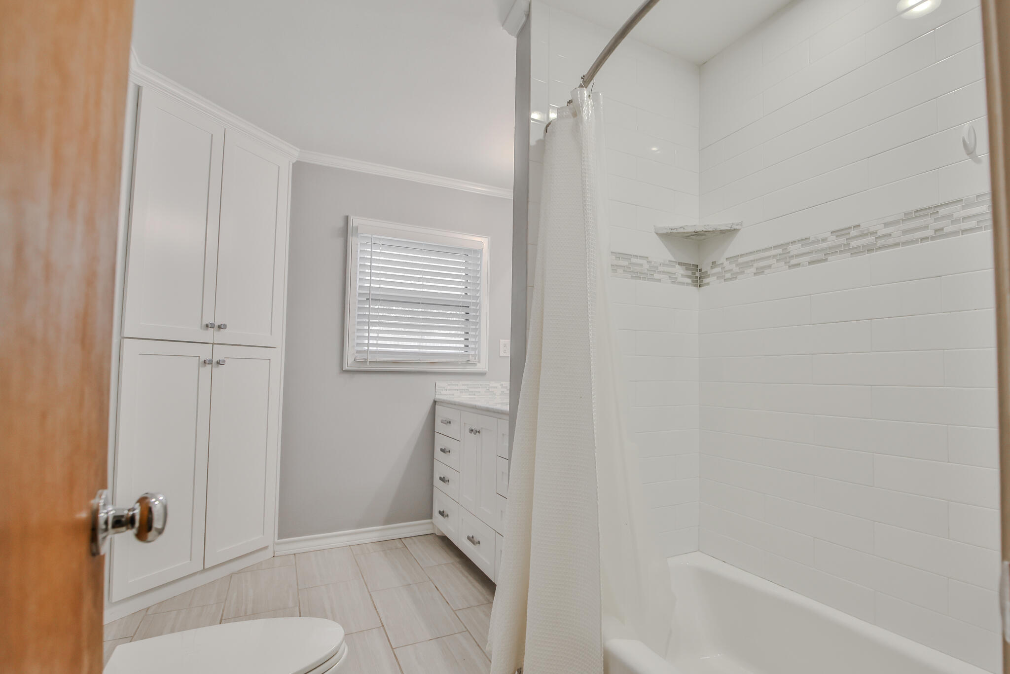 4315 47th Street Lubbock, TX 79413 - Photo 32 of 37 a bathroom with a granite countertop sink a toilet and shower