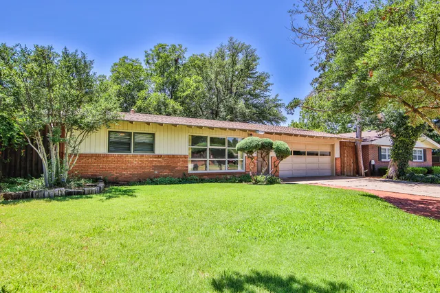 a view of a house with a yard and a patio