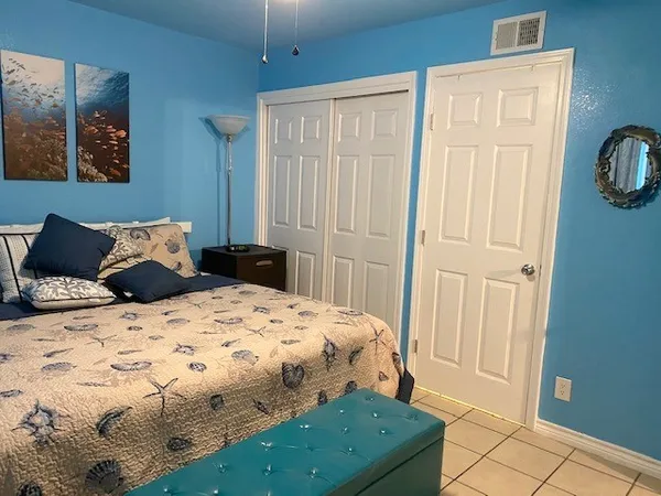 a bedroom with a bed and painting on the wall