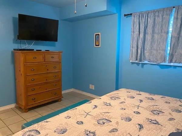 a bedroom with a bed and a flat screen tv