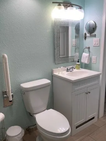 a bathroom with a toilet sink and mirror