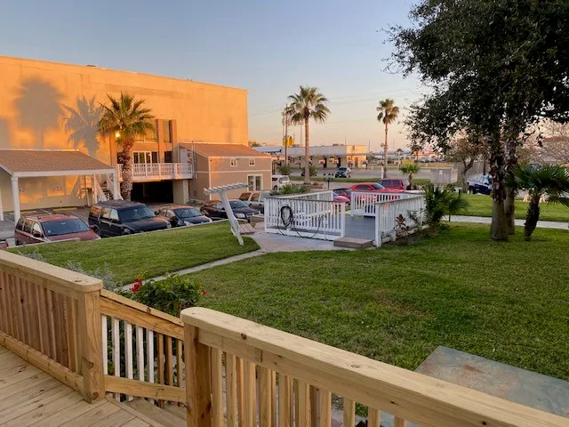 a view of a house with a big yard and palm trees