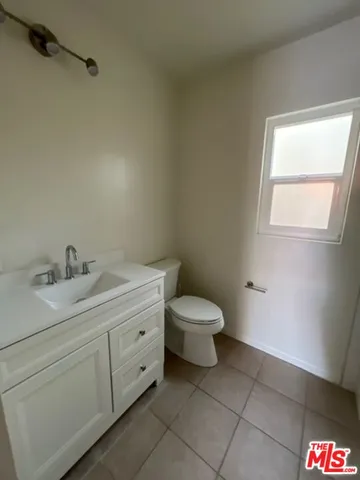 a spacious bathroom with a toilet sink and mirror