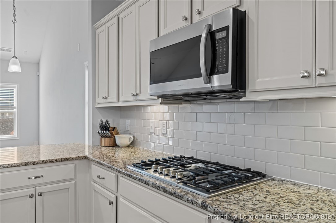 335 Parrish Lane Carthage, NC 28327 - Photo 15 of 50 a kitchen with stainless steel appliances granite countertop white cabinets and a stove a oven with white countertops