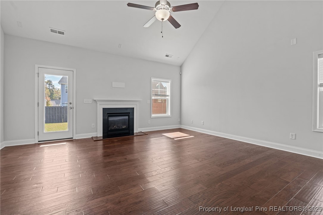 335 Parrish Lane Carthage, NC 28327 - Photo 17 of 50 an empty room with wooden floor fireplace and windows