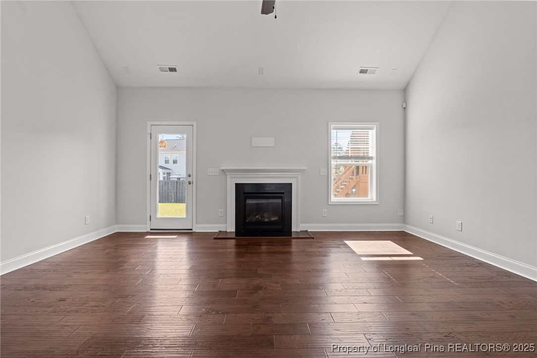 335 Parrish Lane Carthage, NC 28327 - Photo 18 of 50 an empty room with windows a fireplace and wooden floor