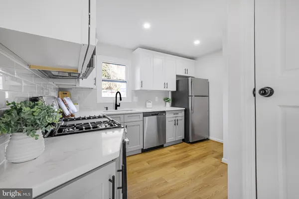 a kitchen with a sink stainless steel appliances a counter space and cabinets