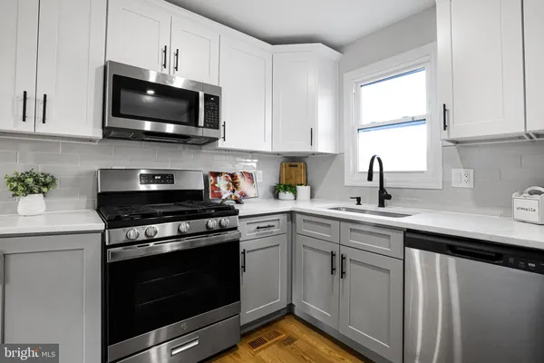a kitchen with white cabinets and appliances
