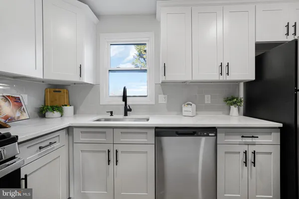 a kitchen with stainless steel appliances granite countertop a sink a refrigerator and cabinets