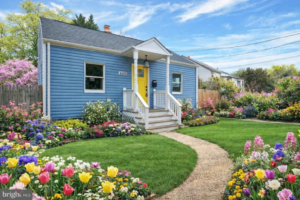 a front view of a house with a big yard and a garden