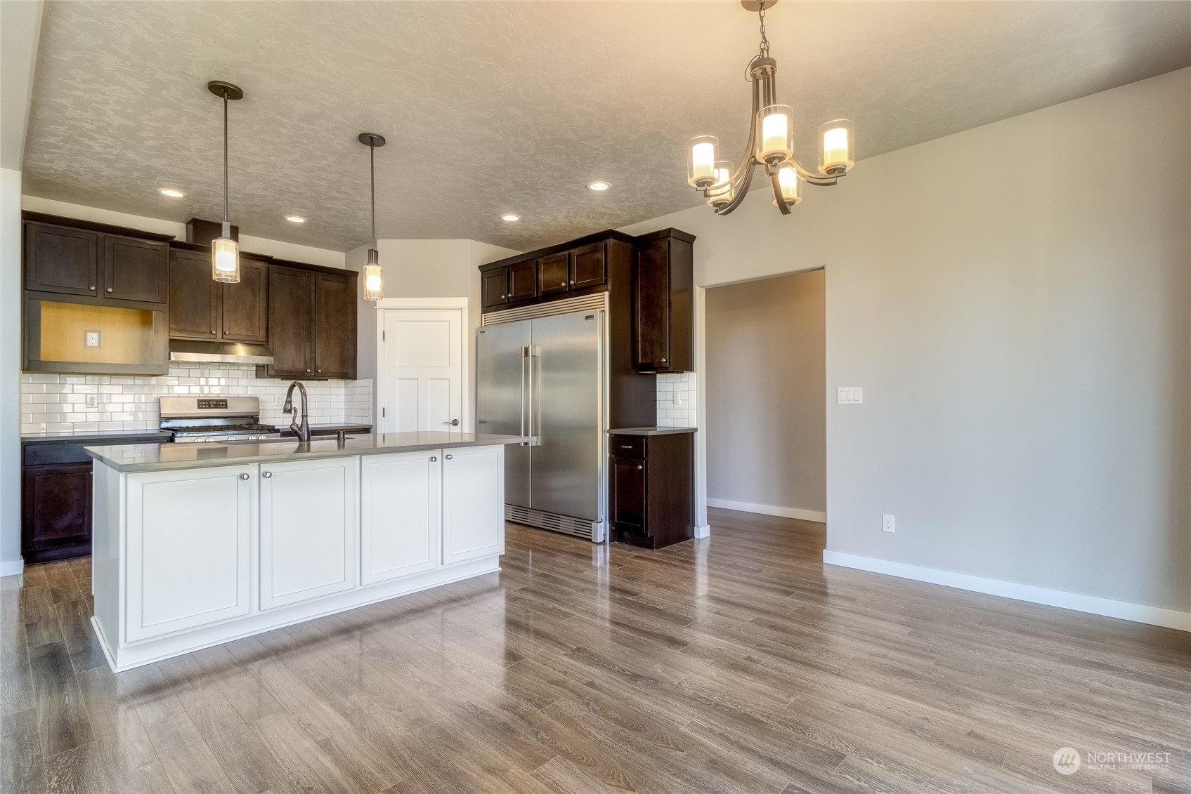 862 Boulder Street Walla Walla, WA 99362 - Photo 9 of 38 a kitchen with stainless steel appliances granite countertop a refrigerator a sink dishwasher a stove and a dining table with wooden floor