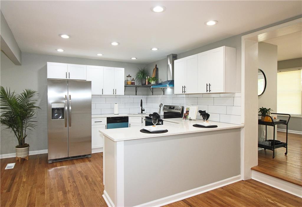 2450 Elkhorn Drive Decatur, GA 30034 - Photo 8 of 32 a kitchen with stainless steel appliances granite countertop a sink a stove a refrigerator cabinets and a dining table with wooden floor