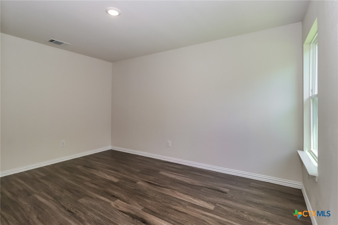 1005 South 22nd Street Temple, TX 76501 - Photo 12 of 21 a view of an empty room with wooden floor and a window