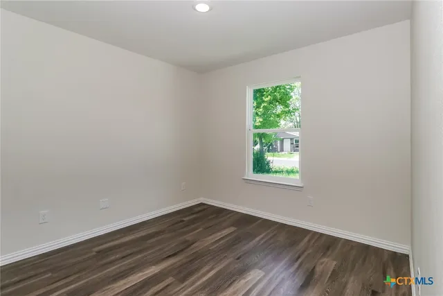 a view of a room that has wooden floor and window