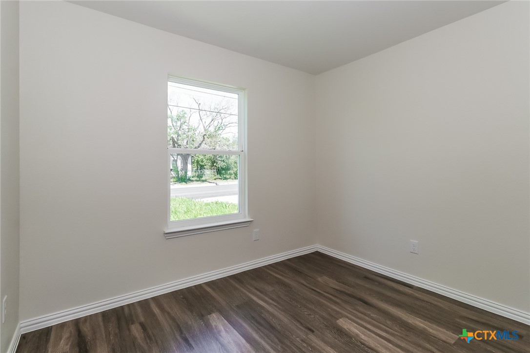 1005 South 22nd Street Temple, TX 76501 - Photo 14 of 21 an empty room with wooden floor and windows