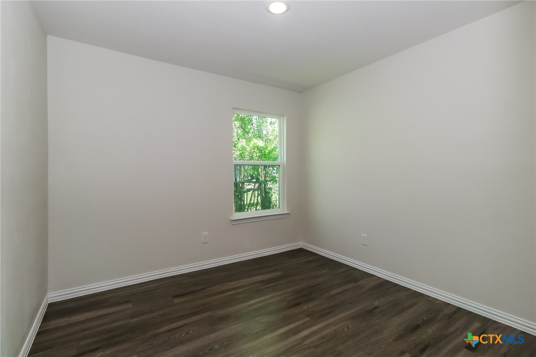 1005 South 22nd Street Temple, TX 76501 - Photo 16 of 21 a view of an empty room with wooden floor and a window