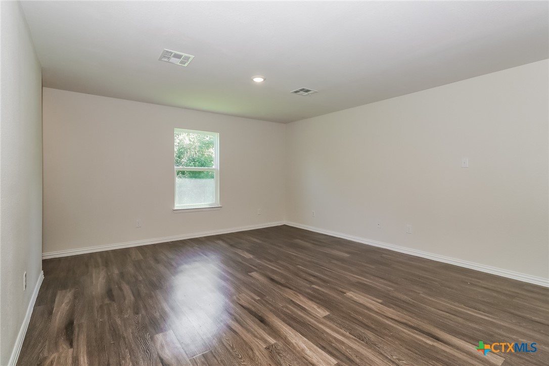 1005 South 22nd Street Temple, TX 76501 - Photo 3 of 21 a view of an empty room with wooden floor and a window