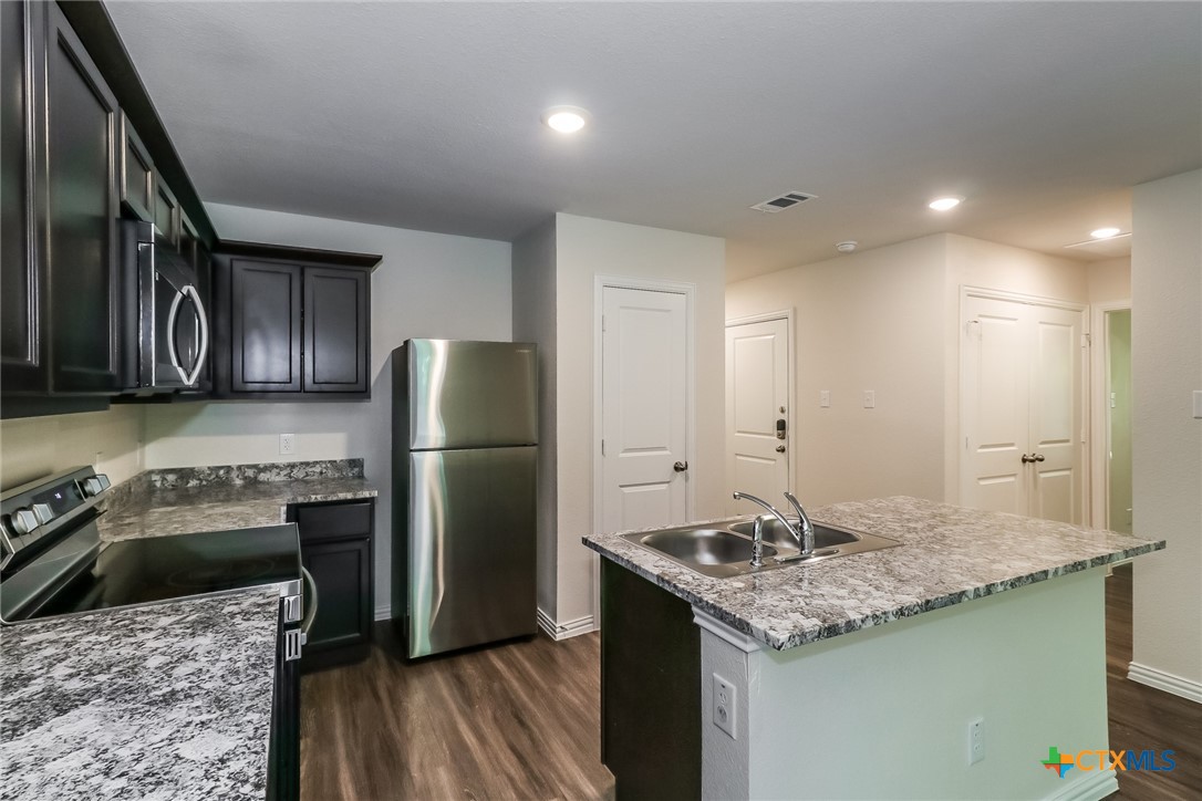 1005 South 22nd Street Temple, TX 76501 - Photo 7 of 21 a kitchen with a stove a refrigerator and a sink