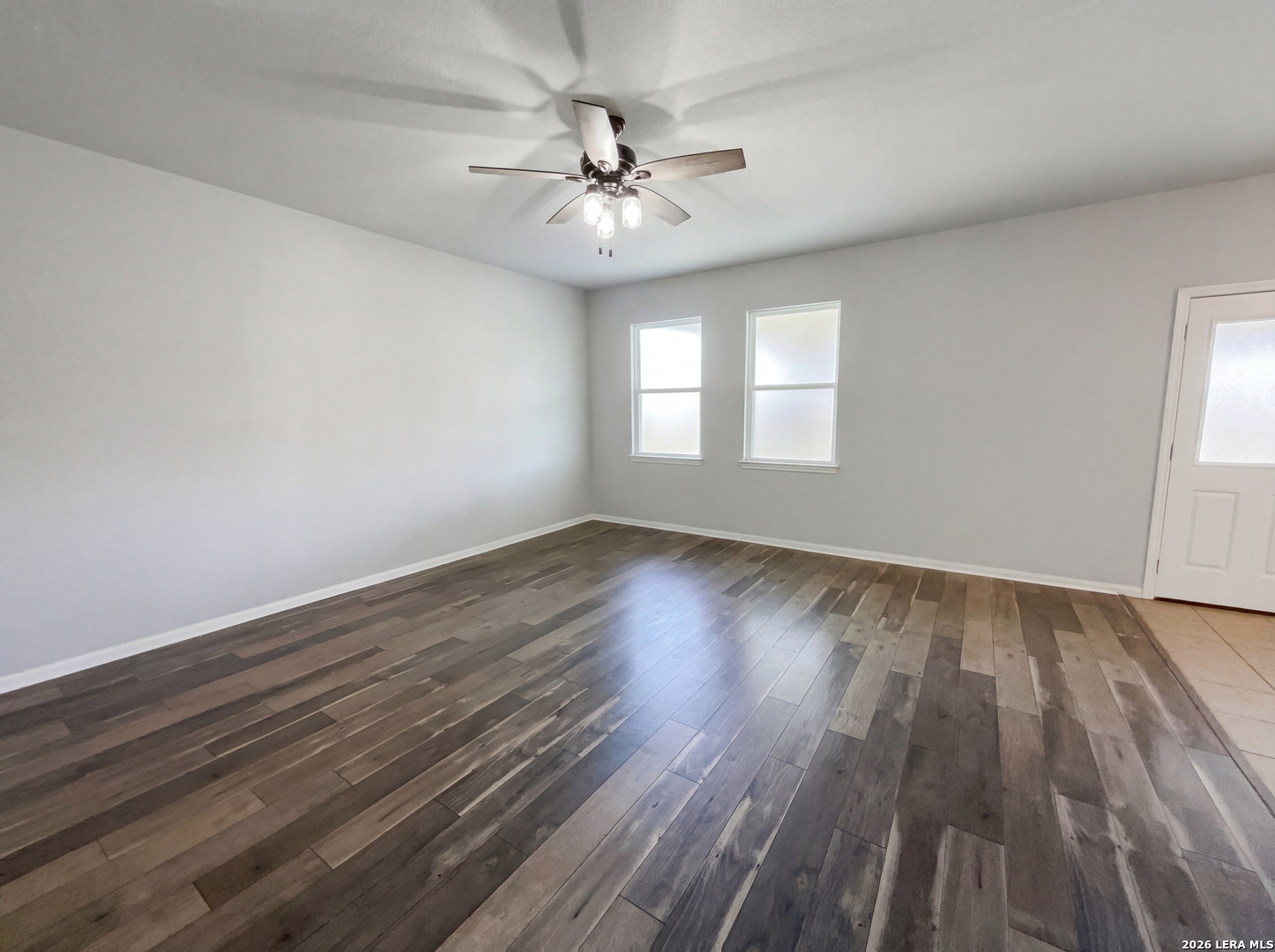 12325 Switchgrass San Antonio, TX 78252 - Photo 3 of 18 an empty room with wooden floor chandelier fan and windows