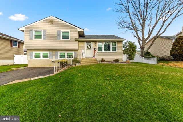 a front view of a house with a yard and trees